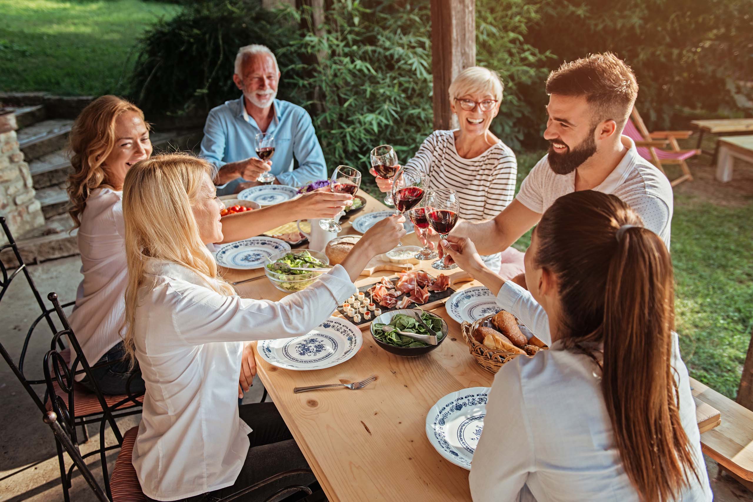 Family cheering over the dining table outdoors